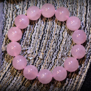 An image showcasing a 3A Grade Madagascar Rose Quartz bracelet, featuring soft pink beads with a smooth surface reflecting captivating luster. Each bead is uniform, with a simple and classic design suitable for various occasions.