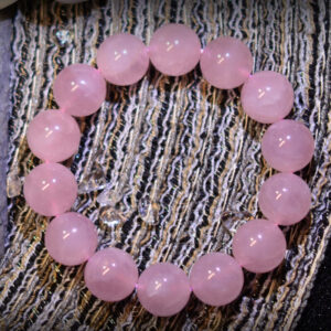 An image showcasing a 3A Grade Madagascar Rose Quartz bracelet, featuring soft pink beads with a smooth surface reflecting captivating luster. Each bead is uniform, with a simple and classic design suitable for various occasions.